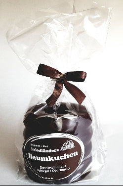 kleiner Baumkuchen mit dunkler Schokolade überzogen im Klarsichtbeutel